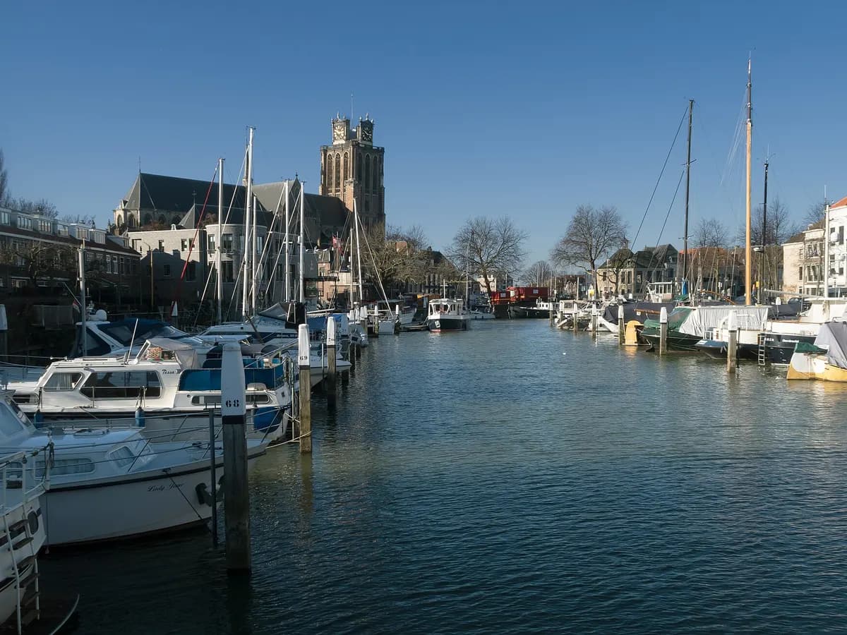 Dordrecht: een gotische kerk met een brede, onafgebouwde toren aan het water